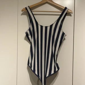 Blåvit Bodysuit från Bikbok - Jättefin bodysuit från bikbok, ärvd av en äldre kusin  Vet ej hur använd den är men inga synliga tecken på användning