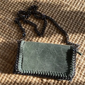 Grön väska - Superfin liten väska köpt i Kroatien i en otroligt härlig grön färg. Går att köra kedjan kortare genom att dra den ett varv under väskans ”lock”. Funkar då super som axelremsväska. 