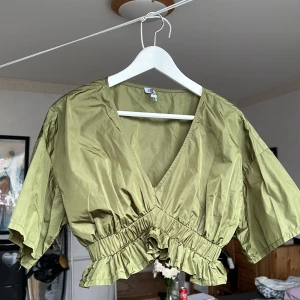 Carrie top - Grön topp i 100% polyester. Glansigt, prassligt material. Fin till fest💚