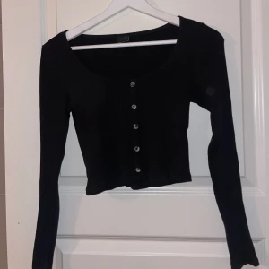 Långärmad svart crop top - En långärmad crop top som har små knappt framför. Aldrig använd