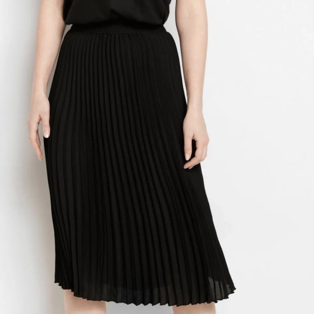 En plisserad svart kjol från NA-KD, storlek M  , bilden är ett liknande exemplar . Kjolar.
