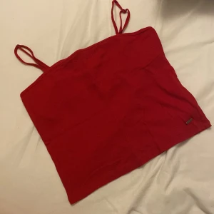 Croppad linne från Hollister - Säljer denna snygga linne från Hollister. I fint skick, använd en gång. Storlek L, passar som M. Croppad. Ribbad. Reglerbara band. 