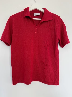 Vintage topp - En pikéliknande vintage topp i rött med blommor broderade. Något croppad. Jättefin men säljer pga änvänder inte längre. Köpt på secondhand. 