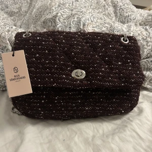 Beck söndergaard väska  - säljer denna jättetrendiga hollis väskan från beck söndergaard, helt ny med lappen kvar! Vinröd med silverkedja. Säljer då den inte kommit till användning. Köpt för 900 säljer för 700kr❤️