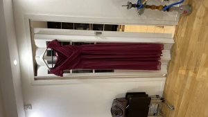 Festklänning - Festklänning i vinröd färg, endast använd 1 gång och i fint skick. Storlek 44 men passar mer någon med storlek 40/42.