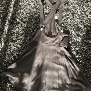 Svart hängselkjol från Divided - Hängselkjol i supermjukt och snyggt fallande tyg, från H&M’s Divided. Storlek 38 Kan mötas i centrala stockholm eller skickas mot frakt 