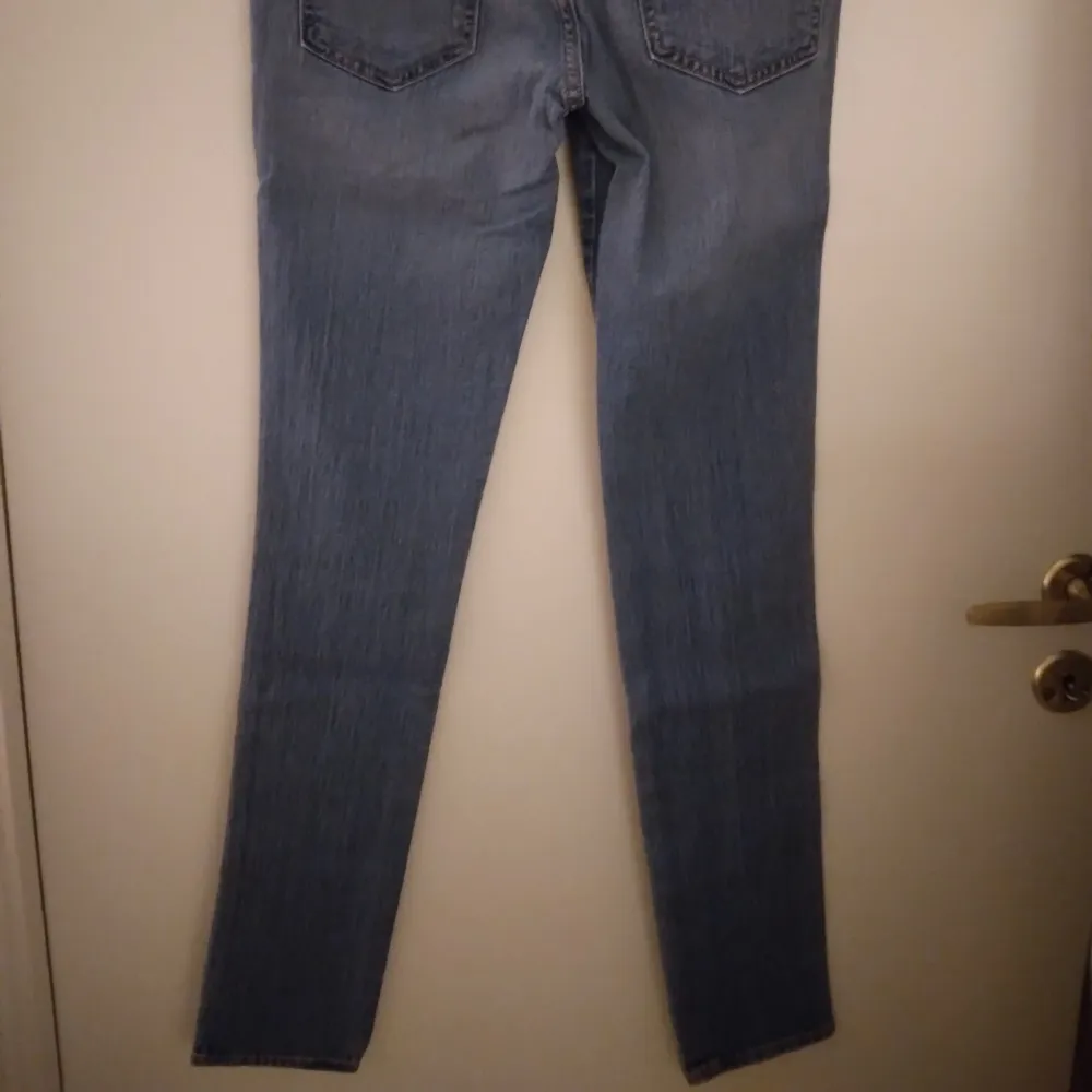 Skinny/smala jeans med raka ben i NYskick. Storlek: 27 i midjan, 32 i längd. Denimblå/mellanblå. Stretchiga. Helt felfria, se bilder för egen bedömning. FRAKT TILLKOMMER.. Jeans & Byxor.