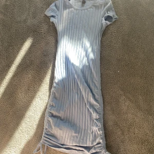 Blå klänning  - Blå tajt klänning från shein i storlek S med ett par slags snören längs ner