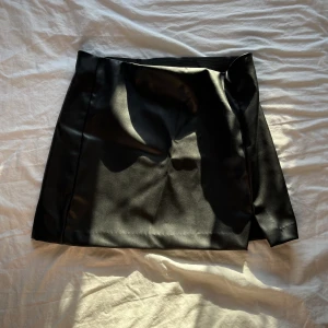 skinnkjol - En svart helt oanvänd skinkjol med lapparna kvar och allting. Säljer då den köptes för 200 kr helt utan användning. Pris kan diskuteras. Ganska stor i storleken, xs men passar s.