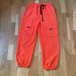 Byxor  - Oversized cargo pants, neon med svarta detaljer. Kan andvandas dagligen, i bra skick, sällan använda 