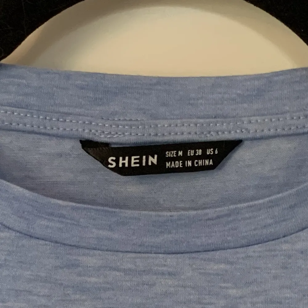 Blå klänning i storlek M från shein med knytning på magen, går till mitten av låren. Klänningar.