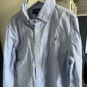 Ralph lauren skorta 12 år - En blå skorta ifrån Ralph lauren som inte är använd speciellt mycket. 