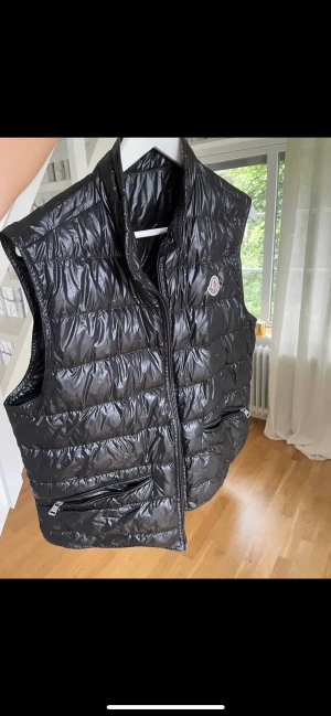 Moncler Väst - Den är använd en del gånger men inga synliga skador förutom under bröstet är det ett litet litet märke.   Priset kan diskuteras och är ej fast i Sten 