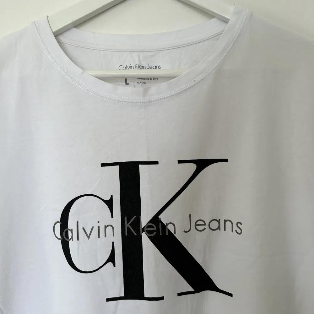 Vit t-shirt med tryck från Calvin Klein.  Använd fåtal gånger. Storlek L 100% cotton ✨✨✨. T-shirts.