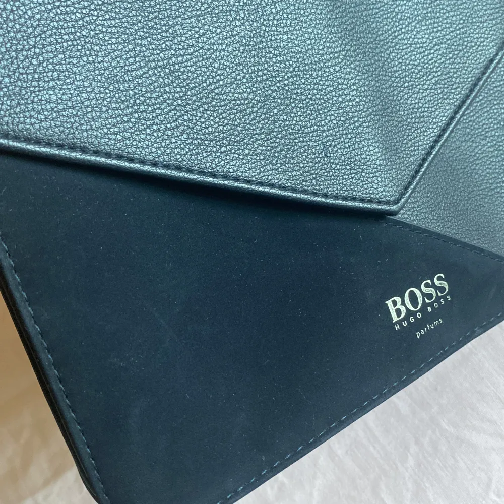 Liten svart kuvertväska i läder och mocka imitation från Hugo BOSS. Accessoarer.