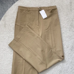 Oanvända kostymbyxor från Mango! - Supersnygga beigea kostymbyxor från Mango! Stretchiga i materialet. Straight, wide leg. Pressveck fram till. Helt oanvända med lapparna kvar; Säljer då de aldrig kom till användning💘