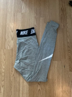 Nike leggings - Superbekväma gråa nikeleggings till träning eller hemmamys. Snyggt brett band upptill som framhäver midjan