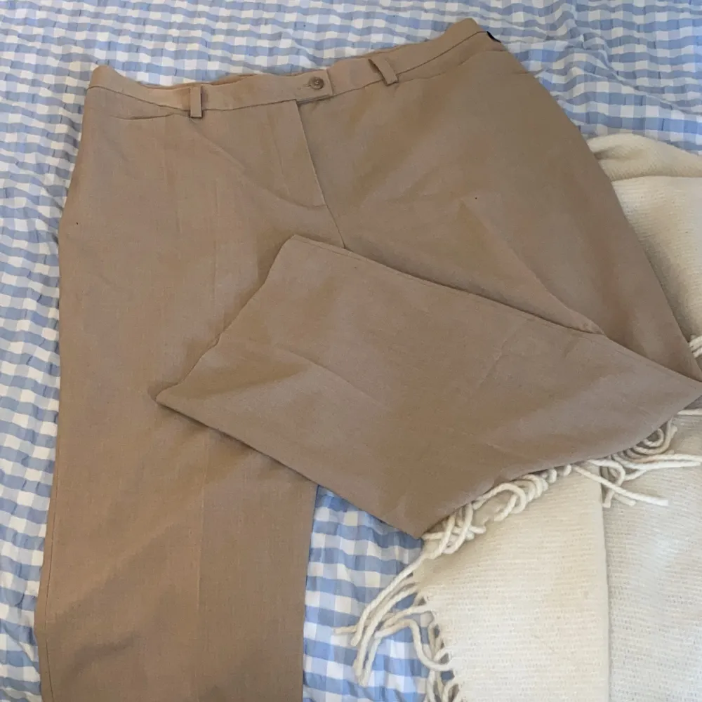 Snygga beiga kostymbyxor från Brandtex i storlek 44 vilket ungefär är W34 L32. Byxorna är i fint skick men några fläckar på baksidan av benet som troligen går bort i tvätten. Det är vida ben och de sitter perfekt. Jeans & Byxor.