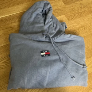 Tommy Jeans hoodie  - Snygg hoodie ifrån Tommy Jeans som är använd max 5 gånger. Storlek XL men passar mig som mestadels har L.  Passform: loose fit Nypris: 1195, mitt pris: 500  Kan skicka mer bilder privat. 