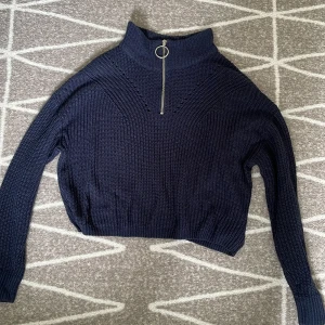 Marinblå stickad tröja - En marinblå stickad tröja som är ganska använd och däravlite ”nopprig”.