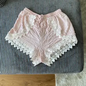 Rosa shorts med vita spets detaljer. Skön och luftig material. 