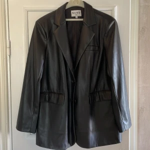 Jacka / kavaj - Oversize jacka / kavaj från NA-KD i läderimitation, 100 % polyester. Storlek 38. Sparsamt använd.  
