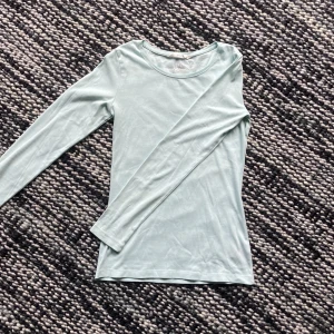 Långärmad tröja - Långärmad figurnära ljusturkos tröja från 00/10-talets H&M logg. Det är från början min mammas men har legat i min garderob i 3 år utan användning, så skicket är bra och sparsamt använt. Inga defekter. Hör av dig om du är intresserad eller har frågor!!