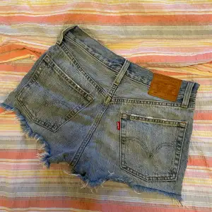 Blå, korta jeansshorts från Levis med slitningar, köpta i New York och använda väldigt få gånger. Storlek W24