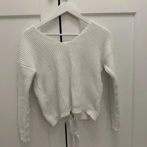 Stickad tröja    - Stickad tröja med öppen rygg. Mycket bra skick på tröjan.  