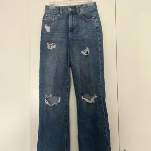 Slitna jeans  - Mellanblåa slitna jeans i nyskick. 