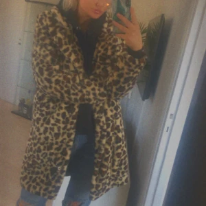 Kappa från NA-KD - As cool kappa i leopardmönster från NA-KD ! Köpt för några år sen men sparsamt använd☺️ det är dock hål i högra fickan men det kan lätt sys igen !