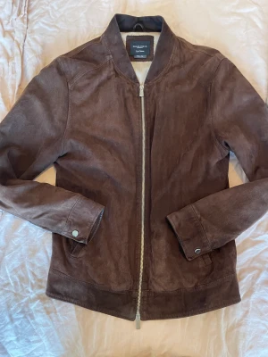 Grand Frank mocka jacka - Jacka i fin kvalite, producerad i Italien.  Ord. Pris: 3199  https://www.grandfrank.com/sv/collections/jackets/products/marloes-suede-jacket-dark-brown