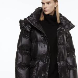 Dunjacka från HM - Dunjacka som endast är testad hemma. Oanvänd. Oversize fit med dragsko i midjan. HMs premium selection. Fluffig och fin i glansig svart färg med stor luva. Fler bilder finns. 
