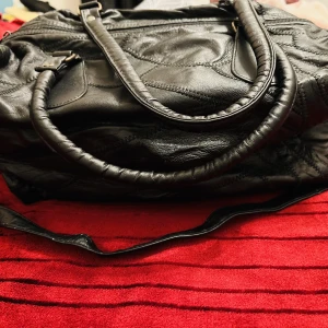Vintage dam weekend bag med axelrem  - Vintage dam axelrem väska i skinn.  Färg: svart skinn.  Yttre och inre fack finns.  Ej använd.   ” obs små slitage finns” 