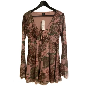 Urban outfitters klänning - Säljer min supersöta Urban outfitters klänning då den inte passar mig. Det finns inbyggda shorts och lappen finns kvar så aldrig använd endast testad! Ärmarna är flared och långa