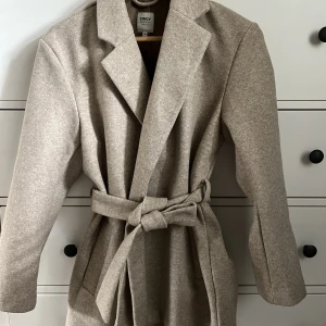 Beige höstkappa - I oanvänt skick. Stl S men liten i storlek. 