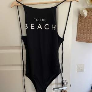 En svart baddräkt från hm med tryck ”to the beach”, bra skick!