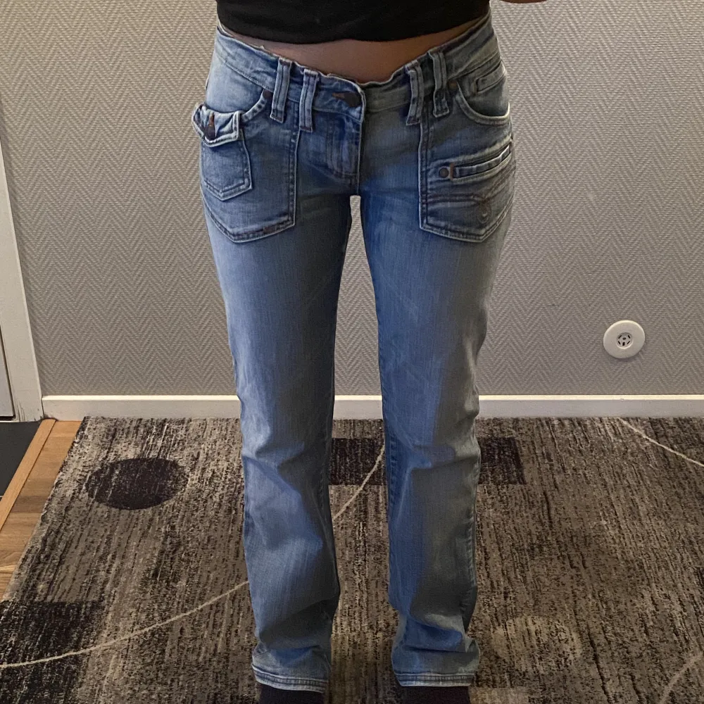 Jättefina utsvängda jeans med låg midja och fickdetaljer⭐️  Innerbenslängd: 83 cm Midja: ca 38 cm Lårvidd: 23 cm 100% bomull  Jeansen är inte så tajta, så de kan passa både s/m :). Jeans & Byxor.