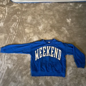 Blå tjocktröjan  - En blå tjocktröja där det står weekend från Lindex storlek 146/152