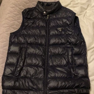 Prada väst - Säljer en blå prada väst i storlek 46! Använd men i väldigt fint skick, 8/10. Kom gärna med bud. Hör av er vid funderingar