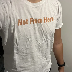Not from here T-shirt - Storlek: L Skick Bra (1 hål på fram och baksida) Material: Bomull Extra info: Köpte år 2021