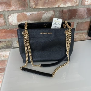 Ny MK väska - Säljer en helt ny äkta MK väska med lapparna kvar.  Äkta skinn Guldfärgade detaljer Supersnygg.  Nypris butik 5300kr Oitletpris 3530kr Mitt pris 3000kr 