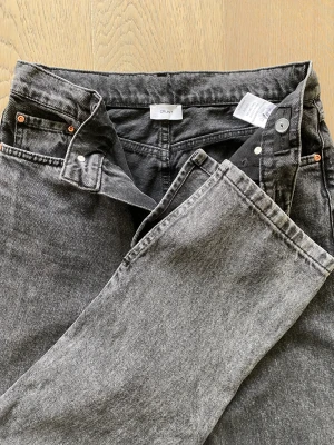 Jeans GRUNT Ritt slit dark grey - Stl 29 Gråa jeans från Grunt med slits nedtill.  Innerbenslängd 83 cm