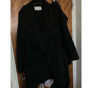 Svart kappa - Svart kappa från Vila, använd fåtal gånger i nyskick. Säljs då den inte kommer till användning längre.