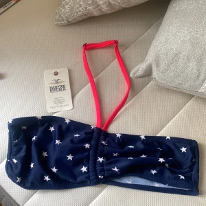 Bikini topp!!! Helt ny. Stjärnor och band runt halsen!  - Det är en bikini topp från Hampton republic. Helt ny. Hittade den bland gamla kläder och då var den redan för liten. Band runt halsen som man kan andra själv!   (Vid köp av denna produkt, får ett par nya gratis örhängen på köpet! 😁)