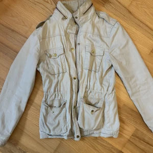 Beige vår/höstjacka  - Ljusbeige, tunn vår/höstjacka från Bikbok. Använd en del, men i gott skick. 