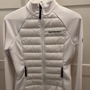 Jacka - En vit jacka från Peak Performance. Jackan har dragkedje fickor med snygga svarta detaljer. Den har aldrig använts och är i storlek XS funkar lika bra för de som bär S och M. Jackan är figursydd. Pris går att diskuteras.