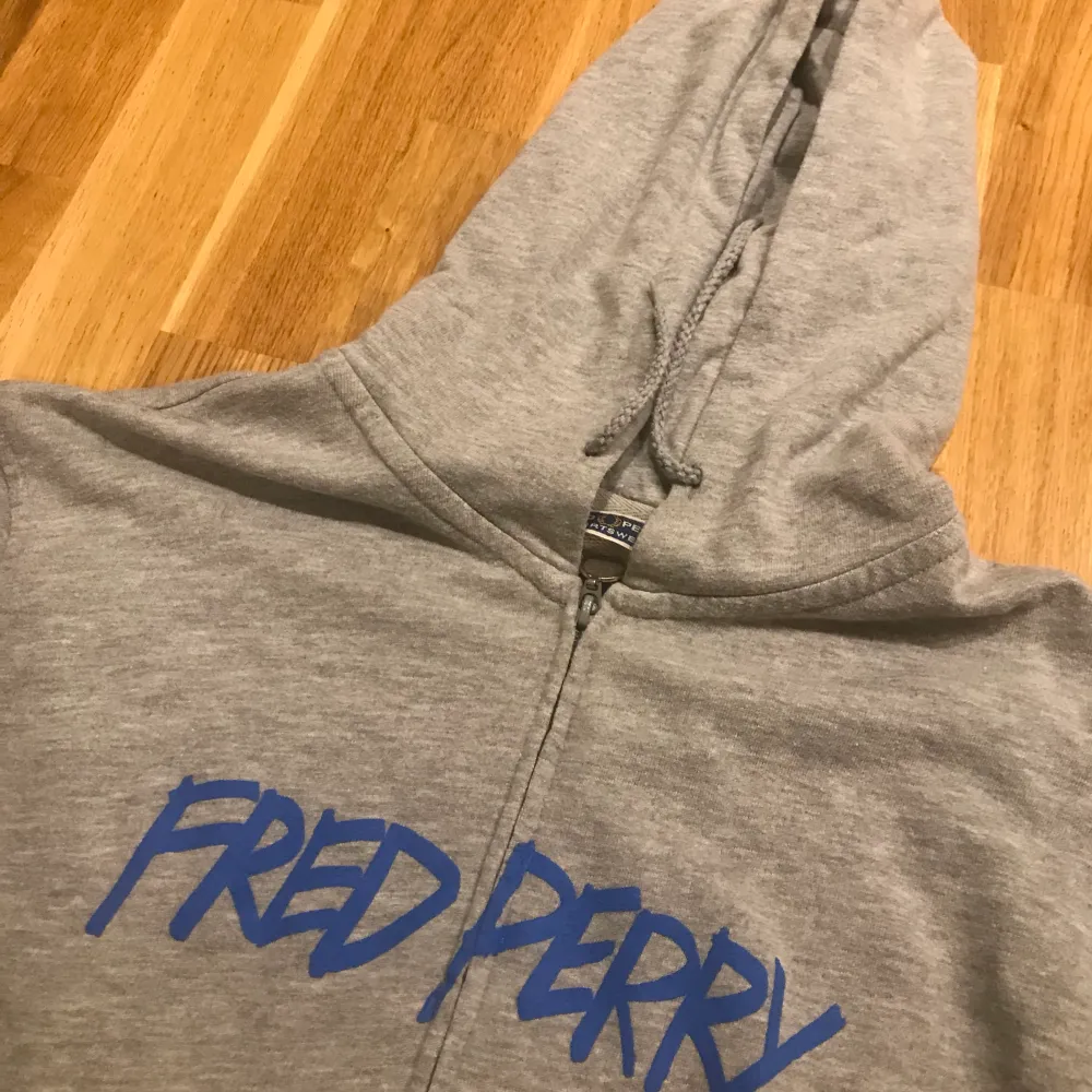 Säljer min gråa Fred perry zip up hoodie då den är lite för liten för mig, den är i perfekt skick och har ett coolt tryck i graffiti stil. Skriv för fler bilder:kr. Hoodies.