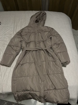 Long puffer coat  - En lång jacka som går till vaderna ungefär,  kan knytas vid midjan och är oversized ,Varm och bekväm inte använd alls för gillade inte hur den satt på mig,  Sälls inte längre Fler bilder kan skickas om nån är intresserad och priset kan diskutera  