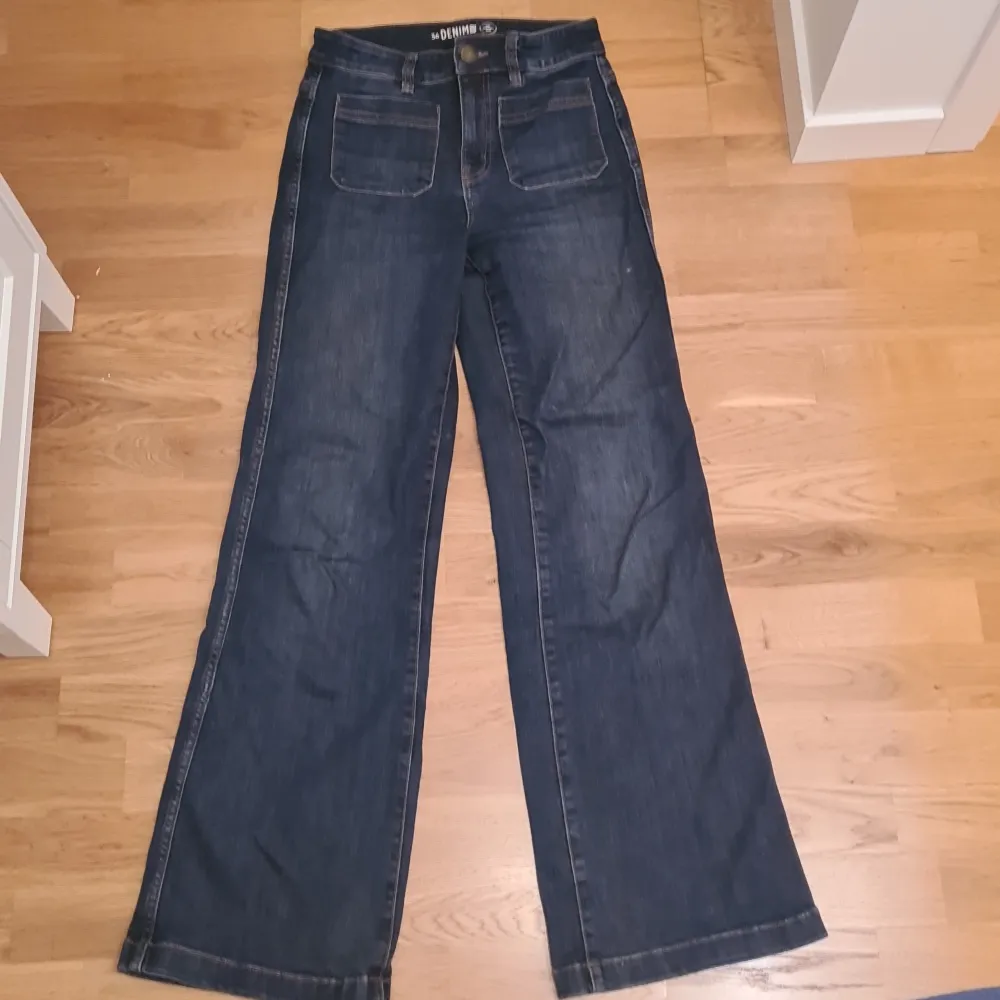 Mid-waisted jeans i storlek 36. Mörkblåa med bruna sömmar. Bra längd för någon som är lite över 170cm lång. Använd ett fåtal gånger och i väldigt bra skick.. Jeans & Byxor.